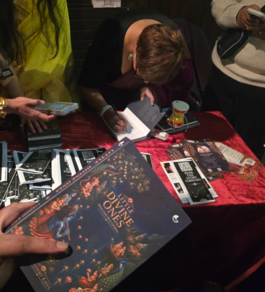 Lakshmi Kaul signing copies of Little Divine Ones at the book signing table after the event at The Bhavan, London